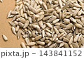 Appetizing peeled sunflower seeds falling in slow motion closeup with rotation on a brown paper surface 143841152