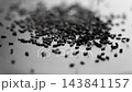 Dry organic sesame seeds falling on a black ceramic plate in slow motion. Uncooked scented spice. Macro shot. Dark view 143841157