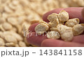 Organic crispy dry oat flakes in grain form falling from hand in slow motion. Macro shot. Healthy breakfast uncooked ingredient 143841158