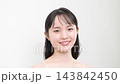 A young woman, appearing to be in her teens or twenties, smiles and looks directly at the camera against a white background, discussing beauty and skin concerns such as acne and adolescent skin problems. 143842450
