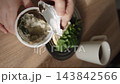 Person opens spoiled yogurt container for breakfast at home, vertical video. Improper product storage, mold growth in dairy product after expiration date. 143842566