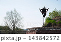 Scary doll in black outfit holds motorcycle handlebars and sways in wind. Halloween building decoration, preparation for holiday party 143842572