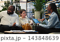 Close up of businesspeople using neural network AI interface on tablet during discussions on rooftop. Team using artificial intelligence tech to devise business strategy from terrace workspace 143848639