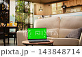 Chroma key display on laptop in bright spacious room with coffee table, wooden furniture with decorative items highlighting a modern and rustic apartment design with no people 143848714