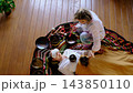 From above, a client lies under a blanket as a therapist leads a sound healing session with metal bowls and soft mallets. The image connects to burnout recovery, self care, and alternative wellness. 143850110