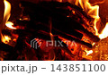 Wooden logs burning in a bright, warm campfire 143851100