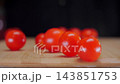 Chef Tosses Cherry Tomatoes onto Cutting Board as They Scatter. 143851753