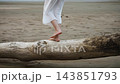 Close-Up of Barefoot Woman Balancing and Walking on Driftwood. 143851793