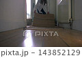 Woman laying floor rug in home hallway 143852129
