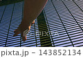 Hand on Intimidating high metal fence  143852134