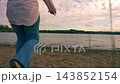 Woman walking on sand towards lake 143852154