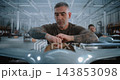 Male Factory Worker Mounting Electronic Circuit Board During Drone Assembly 143853098
