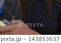 Woman using a yellow-cased smartphone at a street cafe 143853637