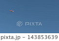 Distant passenger airplane crossing a clear blue sky 143853639