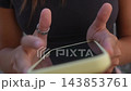 Extreme close view of fingers tapping a yellow-cased smartphone 143853761