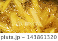 Close-up slow motion fried crispy potato wedges deep frying in oil. French fries 143861320