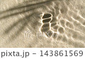 Slow motion water surface ripples and splash with palm tree leaf shadow on sand 143861569