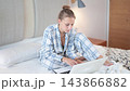 European woman analyzes work tasks on a notebook. Female freelancer working from home  143866882