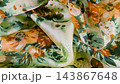 Floral silk fabric gracefully falls onto a white background in slow motion. This elegant dynamic texture is ideal for fashion branding and textile marketing.  143867648