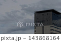 Modern Glass Building Facade Under Overcast Gray Sky 143868164