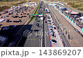 High angle aerial video of start finish straight grid slots Mascot Workwear gantry pit lane paddock with dome tents flags and parking lot at Circuit Zandvoort in North Holland Netherlands footage 143869207