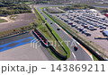 High angle aerial view of race track corner sports car driving asphalt straight tire barriers gravel run off parking lot and coastal sand dunes at Circuit Zandvoort in North Holland Netherlands 143869211