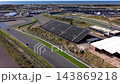 High angle aerial view of race track straight grandstand banked turn sports car driving hospitality building sand dunes and North Sea coastline at Circuit Zandvoort in North Holland Netherlands 143869218