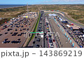 High angle aerial video of start finish straight race track paddock grandstand parking lot campsite dunes and North Sea coast at Circuit Zandvoort in North Holland Netherlands stock footage 143869219