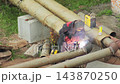 Welder performing welding work on heating main pipe joint outdoors, industrial process of connecting metal elements, worker in protective mask creating strong pipe connection 143870250