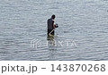 Adult man shallow water instrumental device searching purpose, exploring waterbody surface hidden objects lost items bright sunny day. 143870268