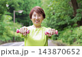 ダンベルを持ってウオーキングする60代女性 143870652