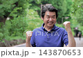 緑の中でガッツポーズをする60代男性 143870653
