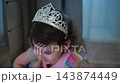 Young girl in princess costume smiles brightly. She wears tiara and rainbow dress. Looking happy, joyful, playful during a celebration. Perfect for birthday events, children's parties 143874449