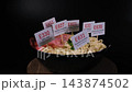 E330, E627, E451, E635 and E621 markers inserted into instant noodles rotating on wooden stand. Processed food warning 143874502