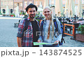 Young tourist couple holding map and smiling in European city plaza 143874525