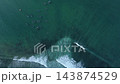 Top down aerial view of surfers waiting for wave in turquoise ocean 143874529