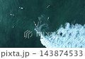 Scenic top down view of surfers in tropical sea water near breaking wave 143874533