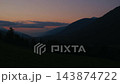 Sunrise illuminating forested mountain ridges and grassy slopes 143874722