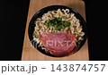A top view shows instant noodles with sausage pieces and parsley on a wooden board as the composition slowly rotates. Quick meal concept 143874757