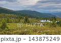 Alpine meadow landscape with mountain vista, distant lake, coniferous forest 143875249