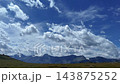 Arctic tundra landscape, mountain range distant, dramatic cumulus clouds, wide angle view 143875252