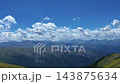 Hikers overlooking alpine valley, mountain range vista, sunny day 143875634