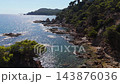 An aerial view of a drone flies over the beach, sea and coastal cliffs near Santa Clotilde Park on a sunny day in the tourist town of Lloret de Mar, Catalonia, Spain 143876036