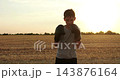 Kid practices boxing punches with gloves in open field at sunset. Outdoor training highlights confidence, discipline and physical fitness, promoting healthy childhood, resilience and active lifestyle. 143876164