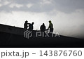 Construction Workers Working on the Top Floor of a High-Rise Building in Windy Weather 143876760