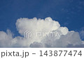 Extreme close-up timelapse of fluffy white cumulus clouds forming and dissolving in a clear blue sky, soft atmospheric nature motion background. 143877474