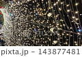 Vertical video. Warm white string light canopy glows overhead at an outdoor Christmas and New Year night celebration. Festive holiday illumination, romantic event decor and sparkling background 143877481