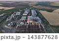 Steelworks production halls, scrap storage yard and exhaust stack in a drone aerial view. Heavy industry, metal recycling and steelmaking feedstock supply infrastructure 143877628