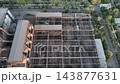 Steelworks scrap yard with storage bays and overhead bridge cranes in a drone aerial view. Metal recycling, scrap sorting, storage and furnace charge preparation 143877631