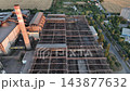 Steelworks scrap yard with storage bays and bridge cranes in a drone aerial view. Metal recycling, steel manufacturing and furnace charge preparation 143877632